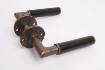 Deurkruk Bauhaus rond brons antiek en zwart ebben met rozetten per paar