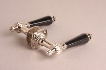 Deurklink blinkend nikkel met ribbel, zwart porselein en rozetten per paar